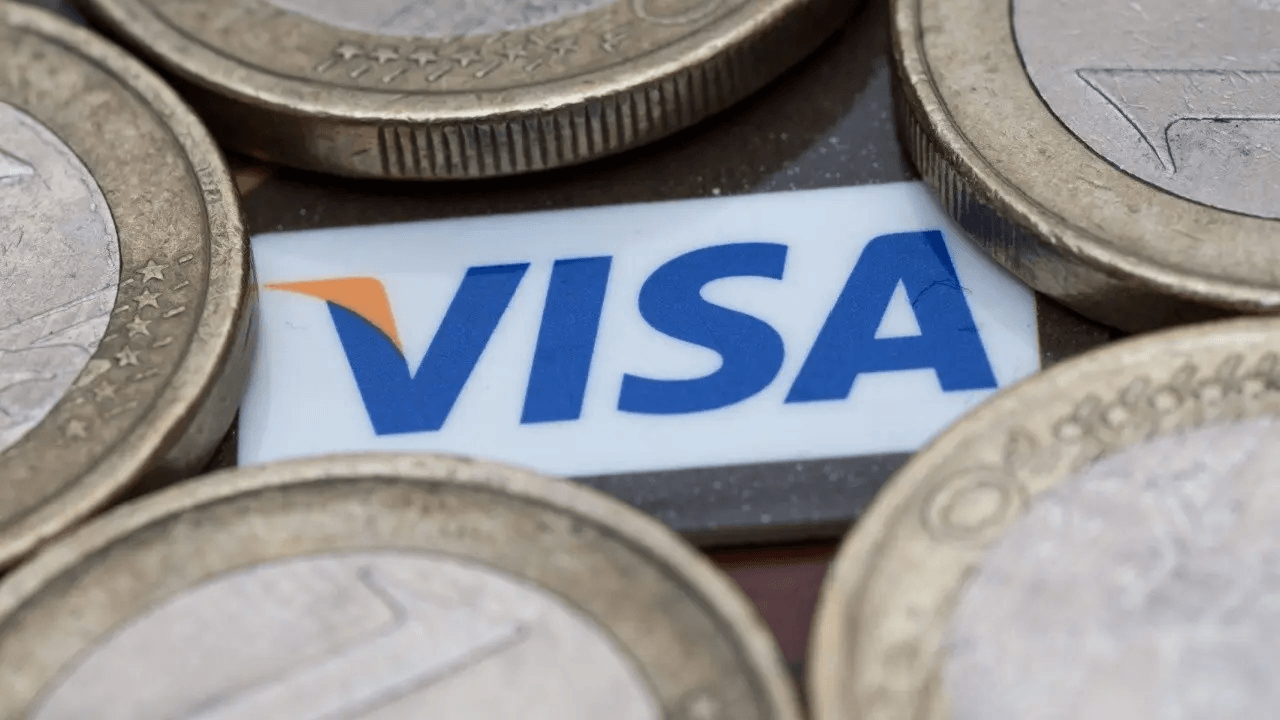 Visa card near stacks of coins.