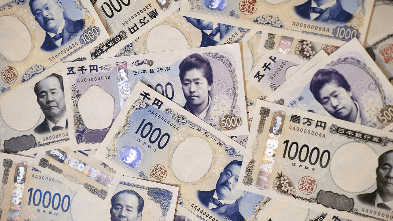 A scattered pile of Japanese yen banknotes featuring multiple denominations spread across a surface.