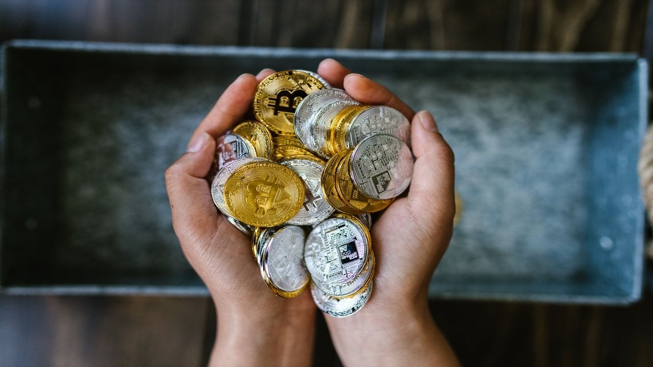 Image showing a person with many physical Bitcoin tokens in their hand.