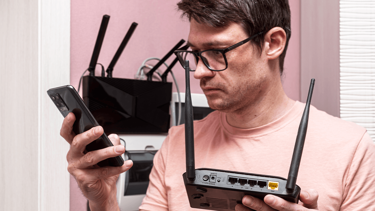 Man looking at a WiFi router in his home.