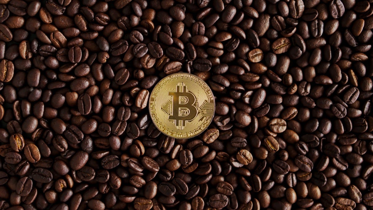 A bitcoin token on top of a coffee grains